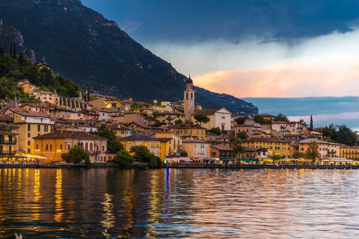 Scorcio di Limone sul Garda durante una festa in piazza, con luminarie, bancarelle di prodotti tipici e il lago sullo sfondo